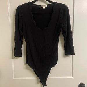 Woman’s black bodysuit with cute scalloped neckline